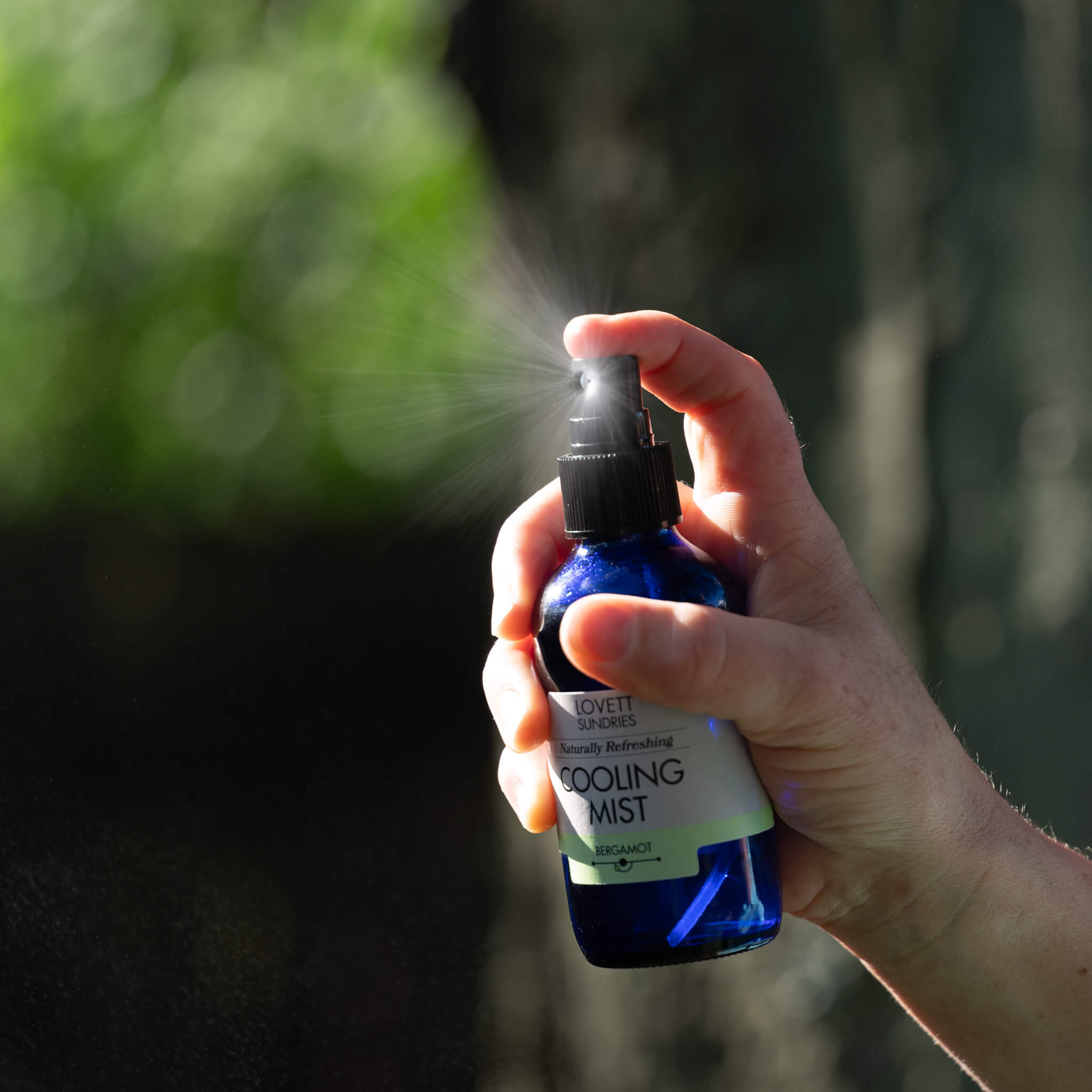 Marit spritzing cooling mist in the sunny back yard.