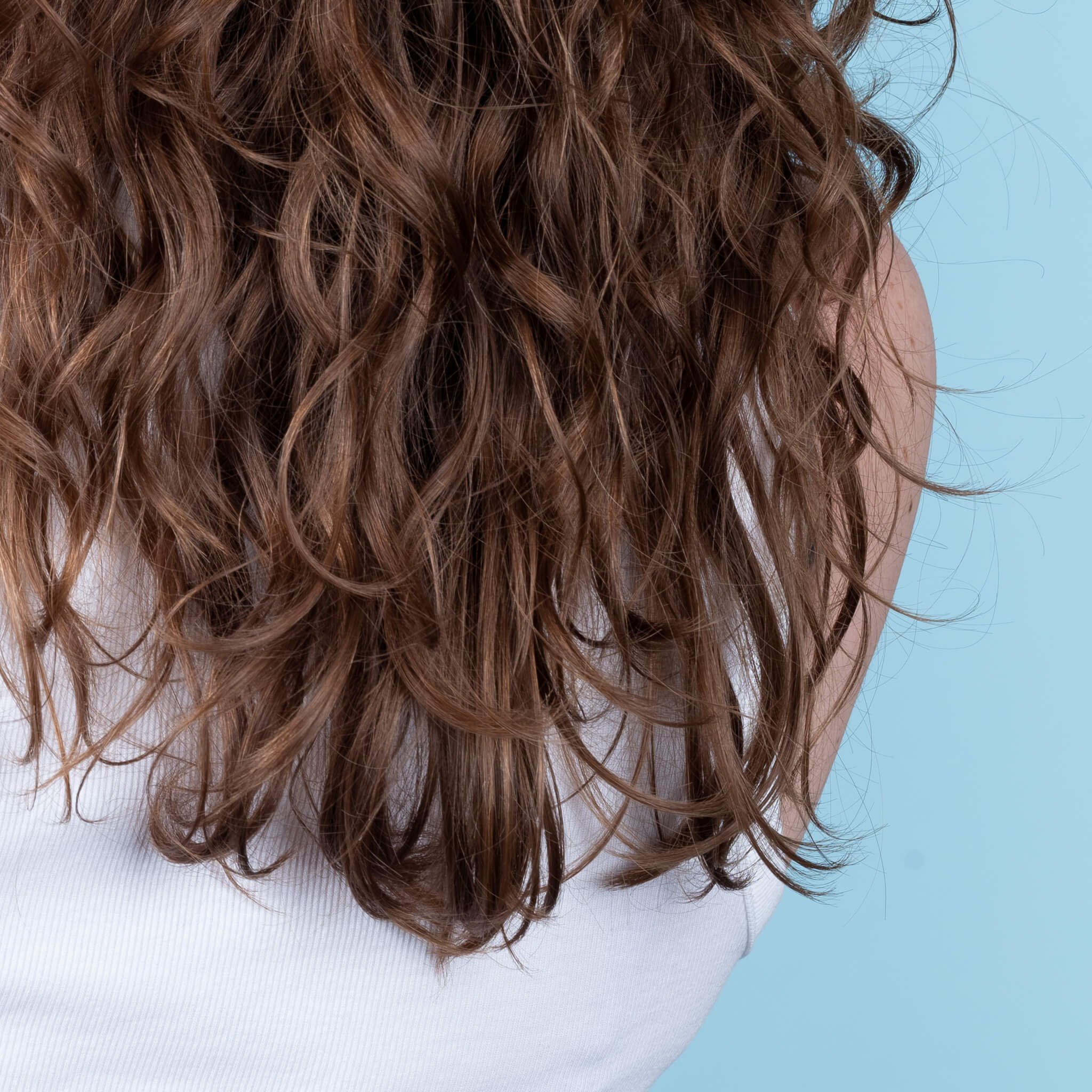Close up of John running his fingers through his styled hair.