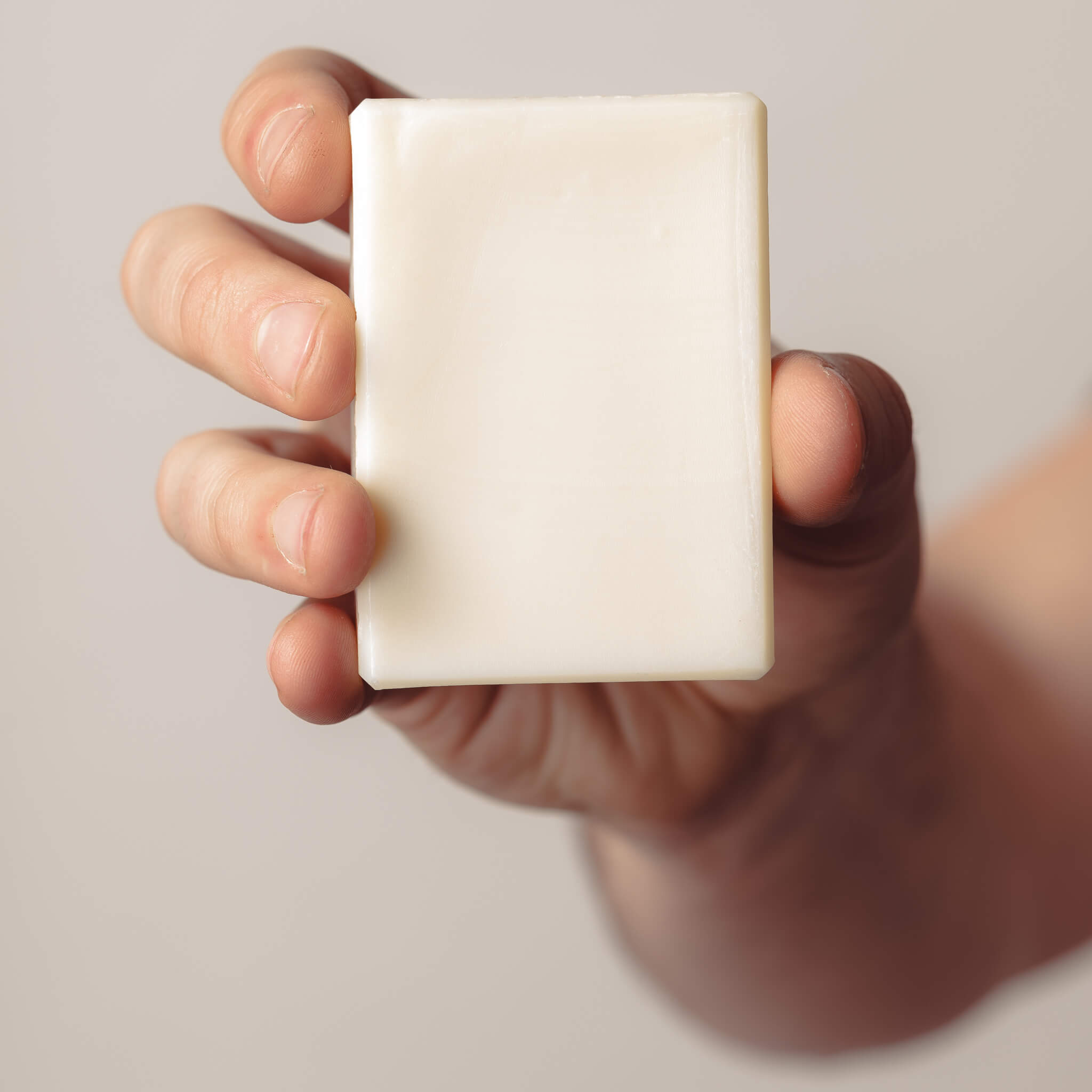 Hand holding all nature pure olive oil soap.