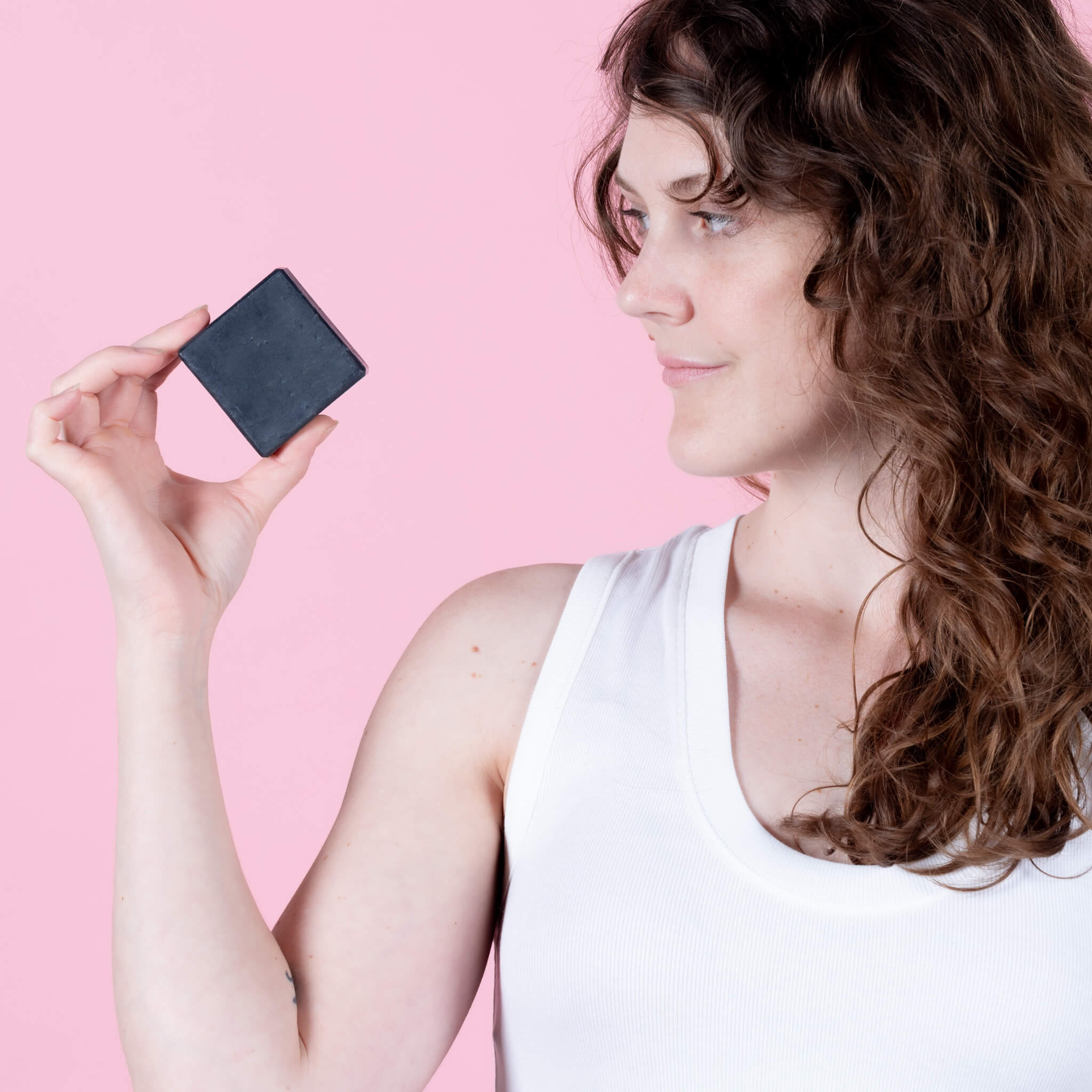Steph holding a bar of all natural charcoal facial soap.