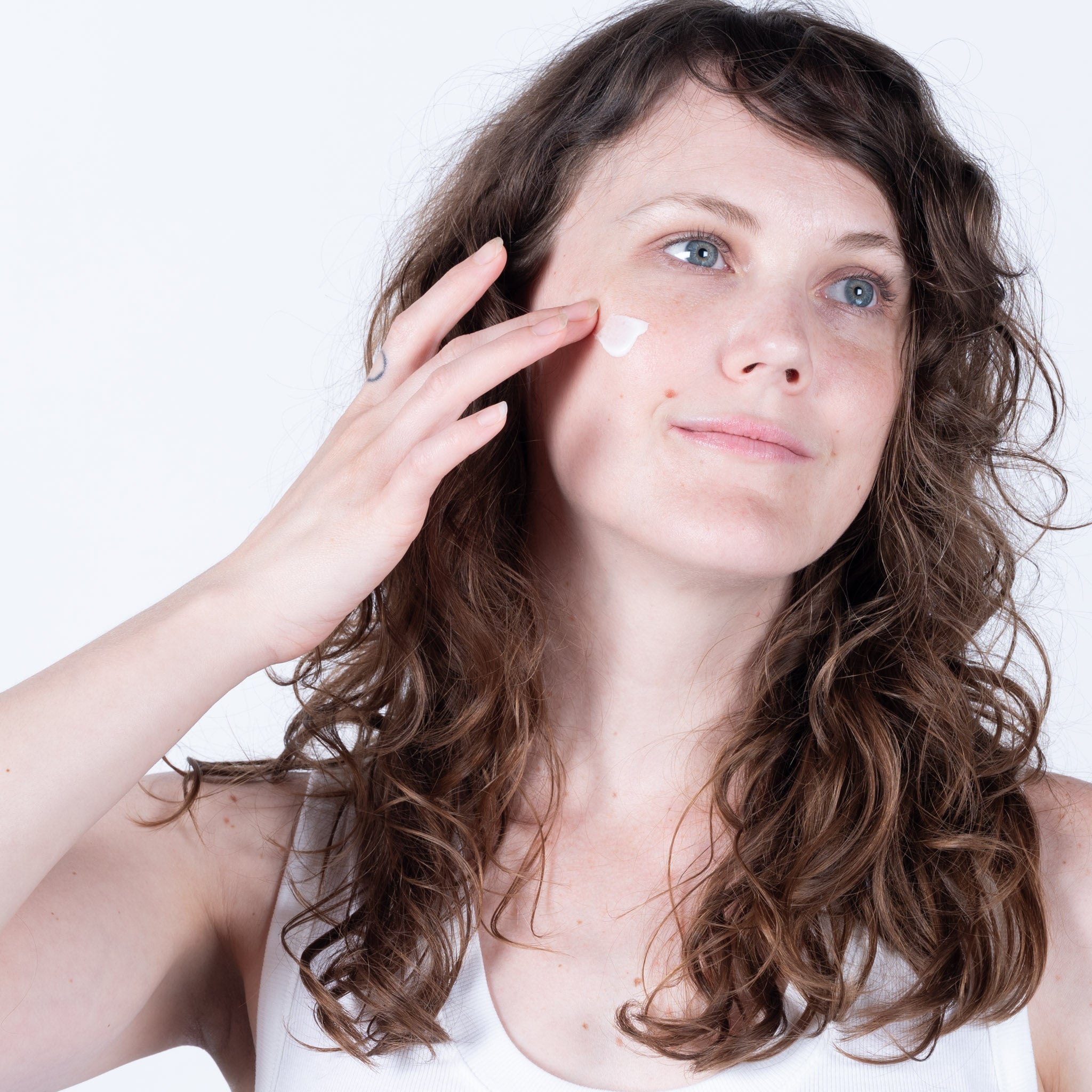 Stephanie applying all natural rosewater face cream to her cheek.