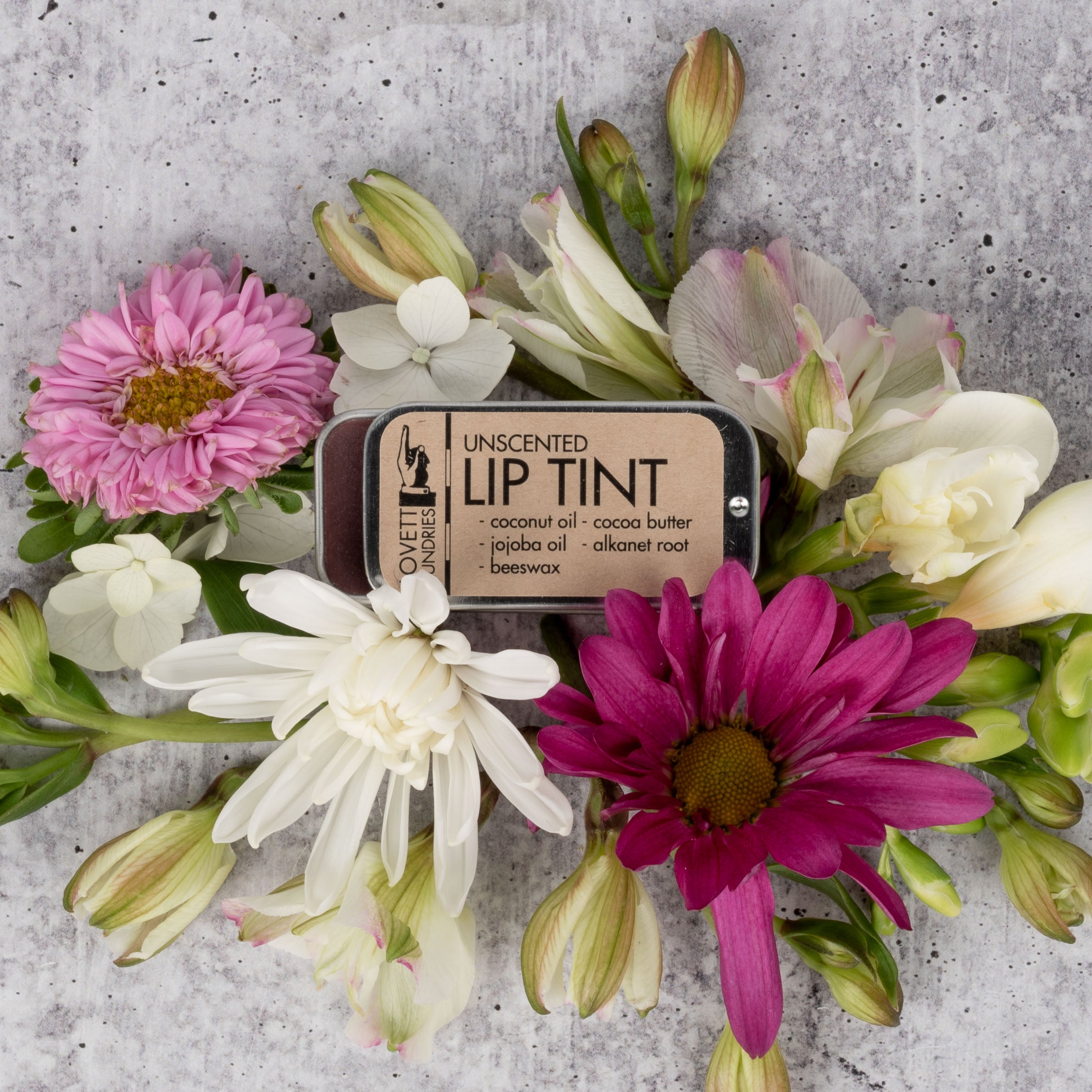 Unscented All-Natural Lip Tint surrounded by flowers.