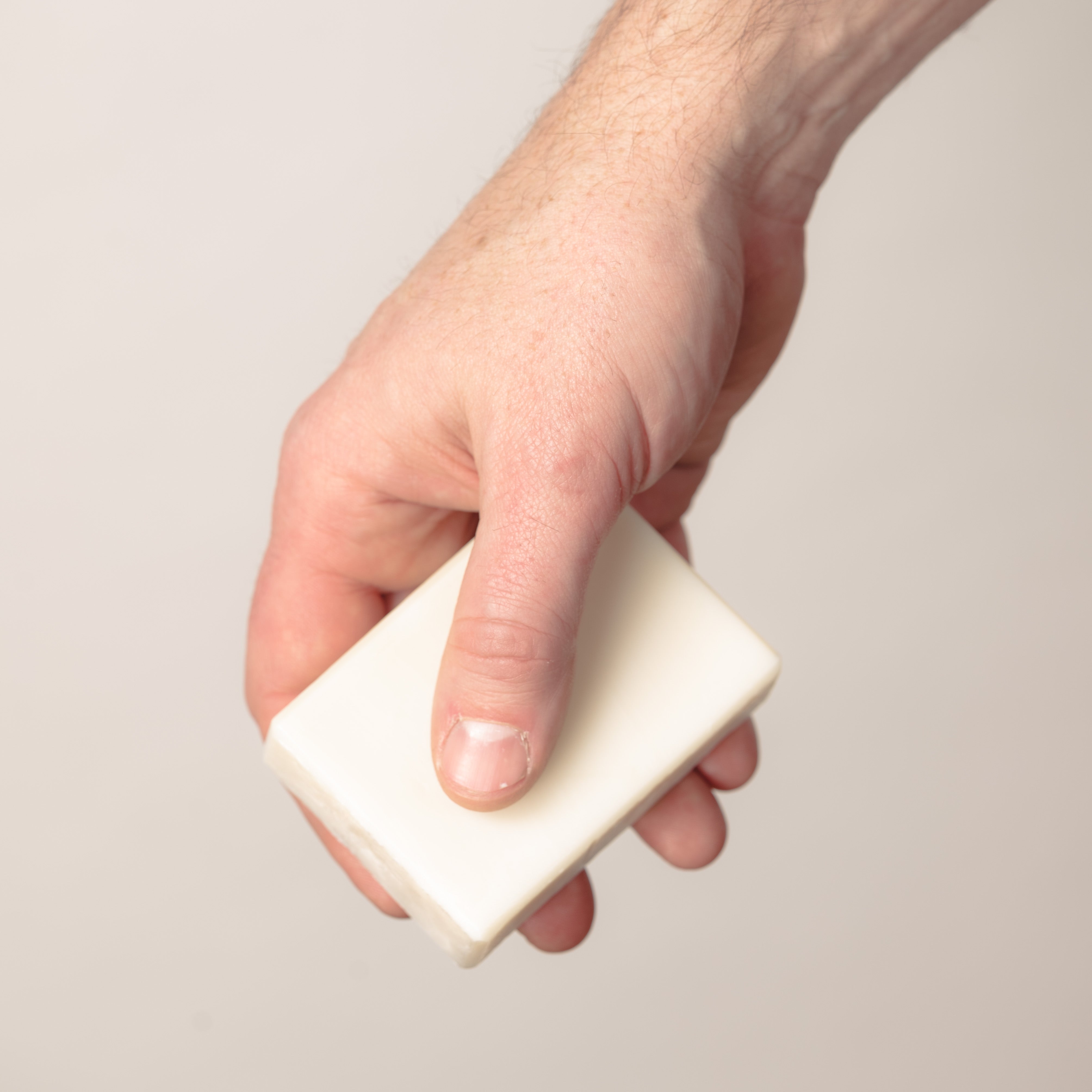 Person holding an olive oil soap bar.