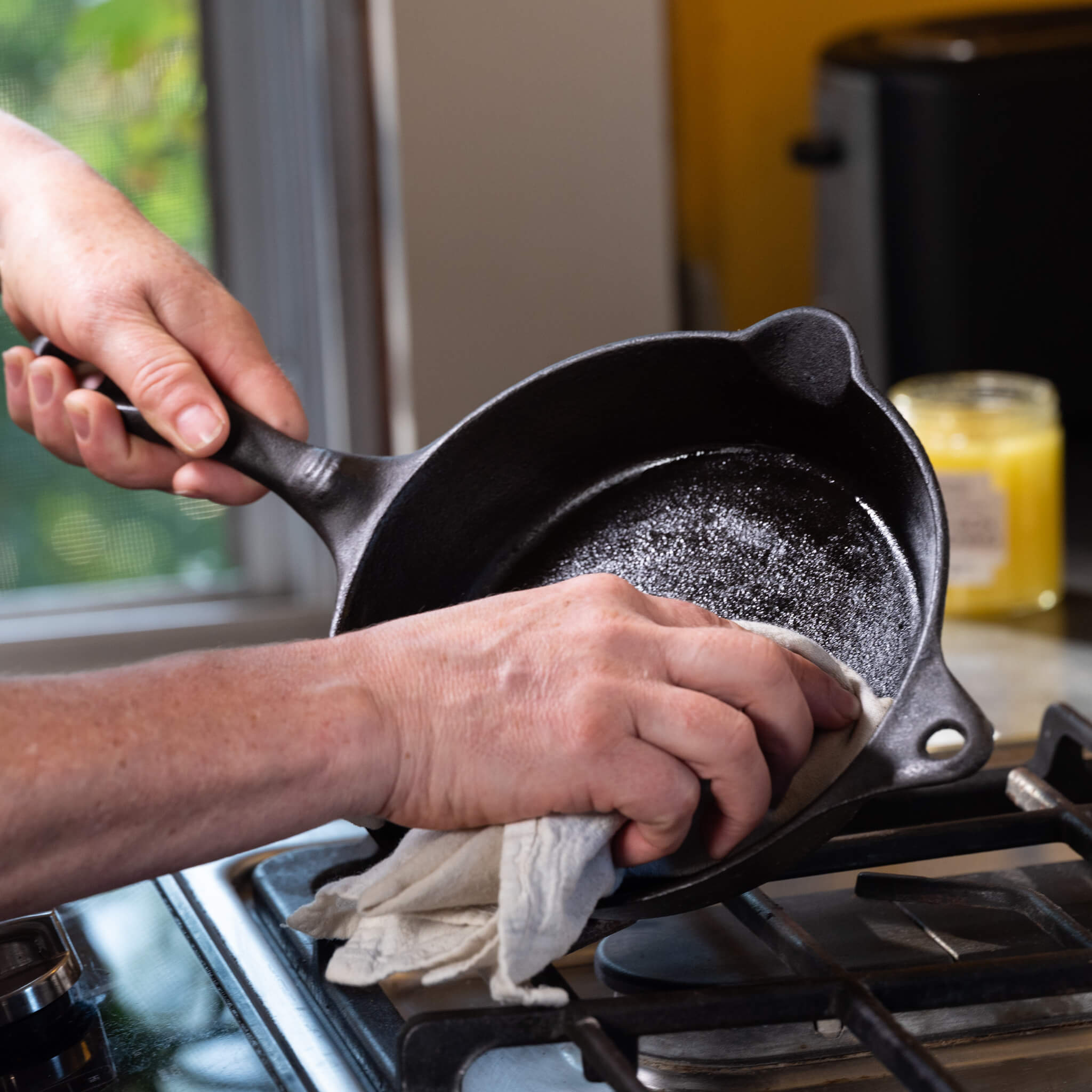 Marit wiping a thin layer of cast iron seasoning oil on her vintage skillet.