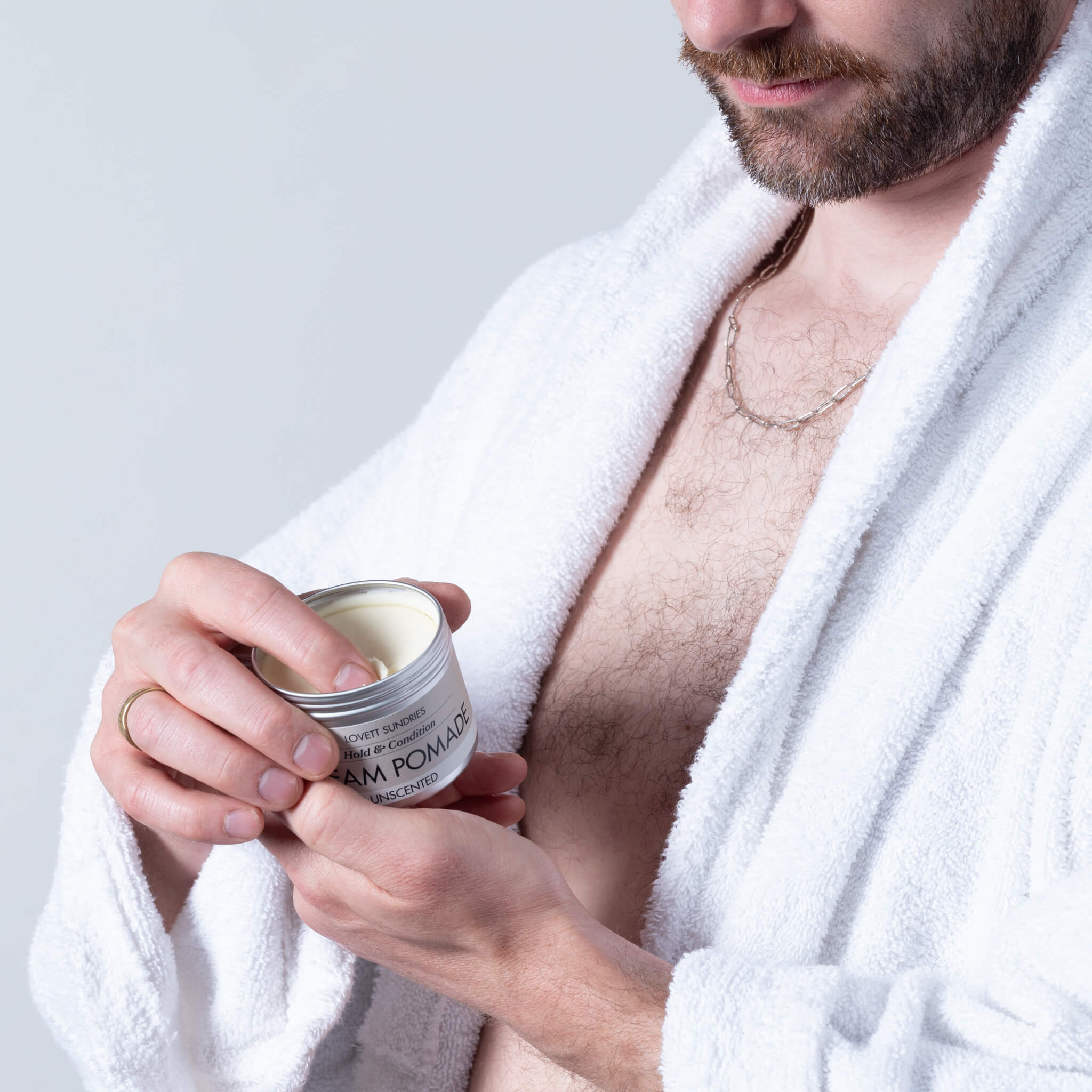 John dipping into a fresh tin of cream pomade.