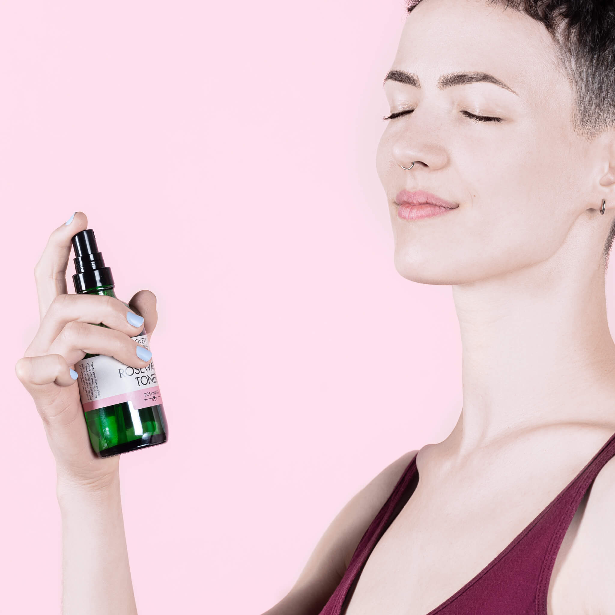 Kari spritzing her face with an all natural rosewater toner in a zerowaste glass bottle. 