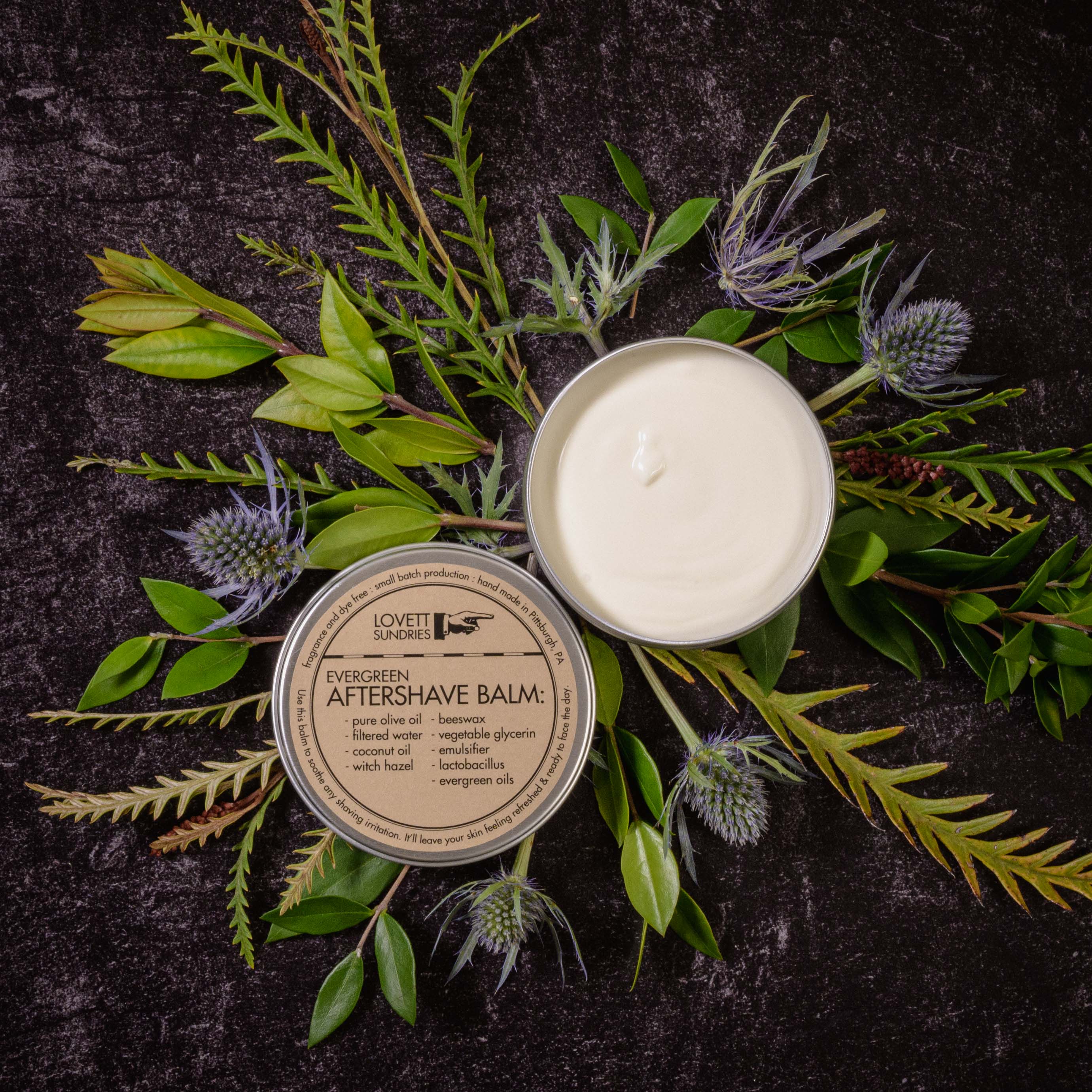 A tin of natural evergreen aftershave balm set on top of flowers.