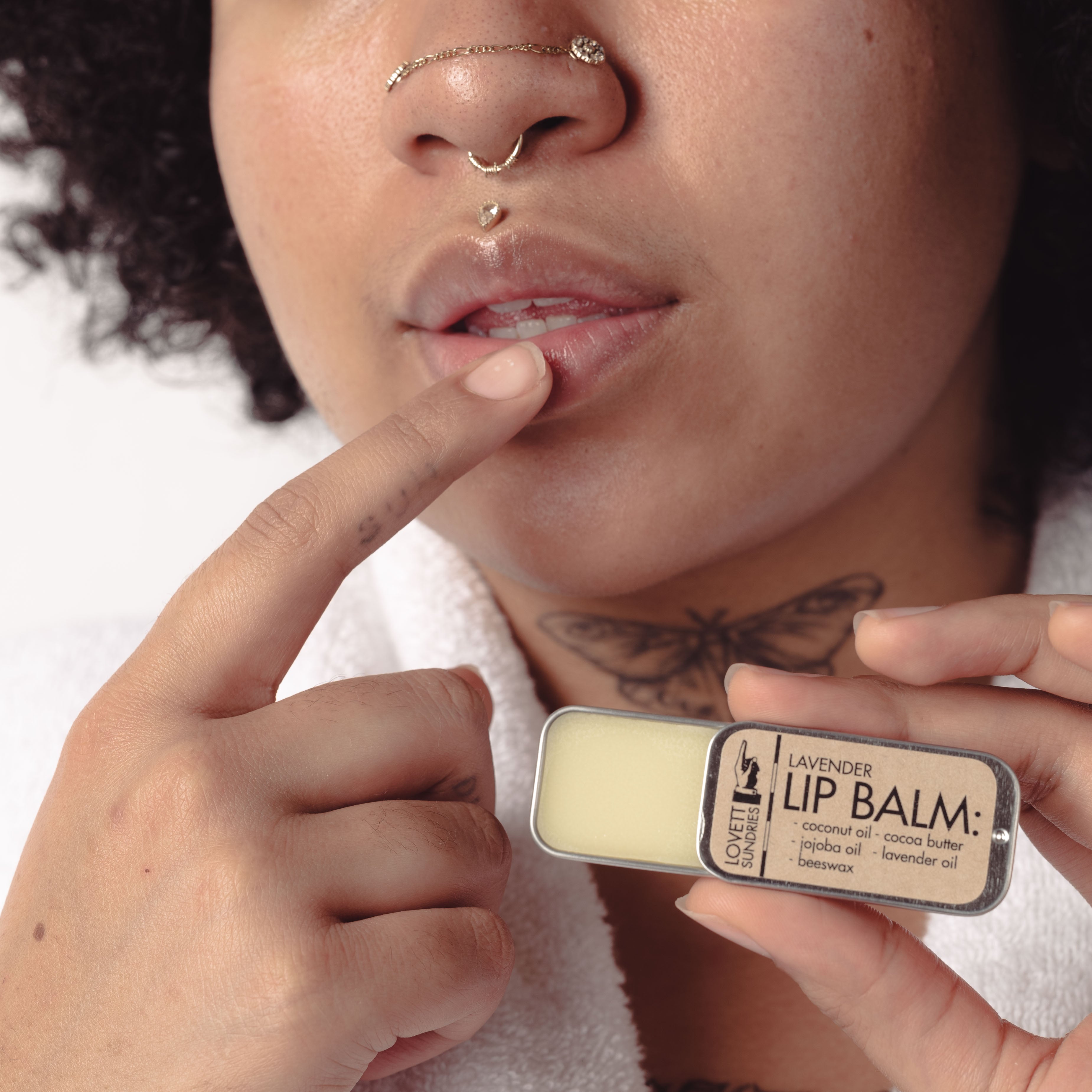 Woman applying lavender All-Natural Lip Balm to her lips.